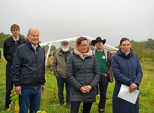 Exkursion im KoMBI-Projekt ©M. Stüber, DVL Dr. Olivia Kummel (re), Geschäftsführerin des LPV Potsdamer Kulturlandschaft, erläutert Altkanzler Olaf Scholz MdB (li) und Brandenburgs Landwirtschaftsministerin Hanka Mittelstädt MdL (Mitte) die Tätigkeit der Kooperative des LPV.